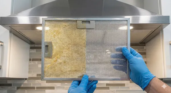 Before and after comparison of range hood filter showing thorough detail cleaning